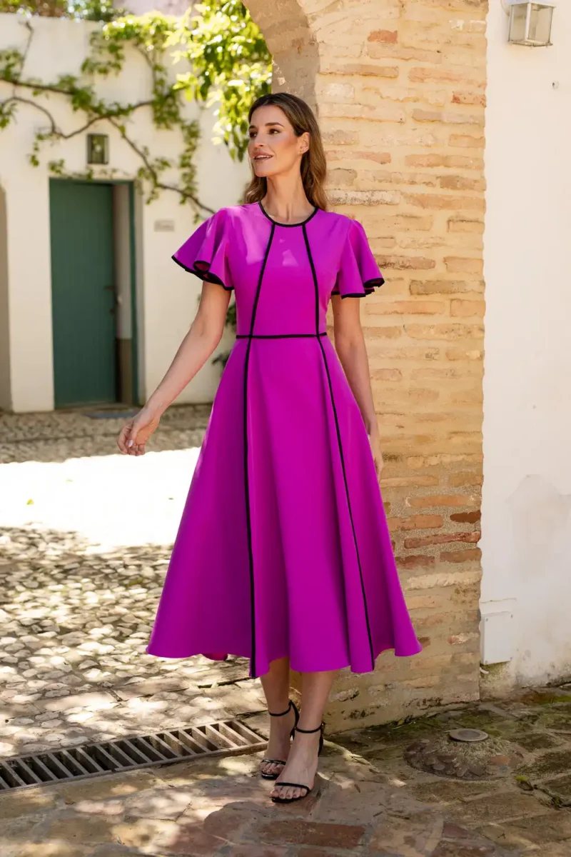 Vestido midi fucsia con vivos de decoraciรณn y volantes en las mangas.