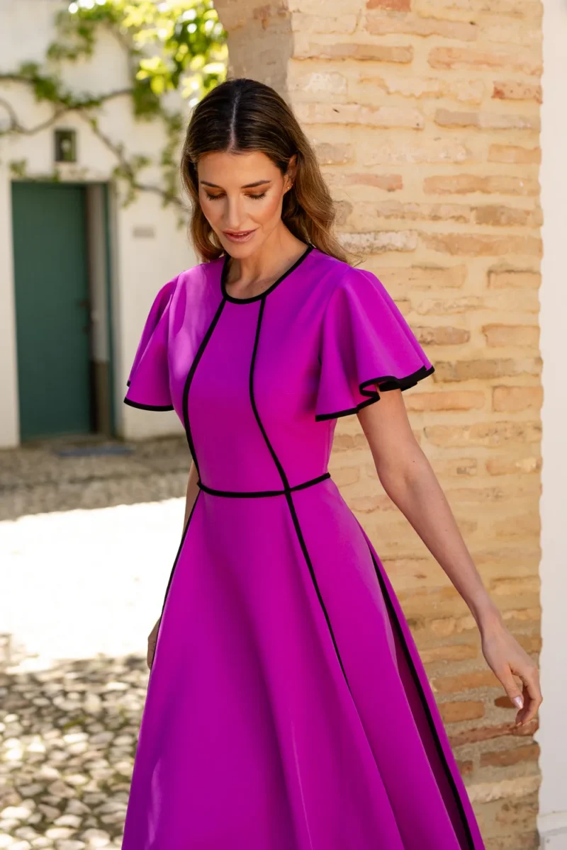 Vestido midi fucsia con vivos de decoraciรณn y volantes en las mangas.